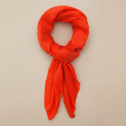 Neon orange cashmere scarf on an edge-to-edge warm beige background