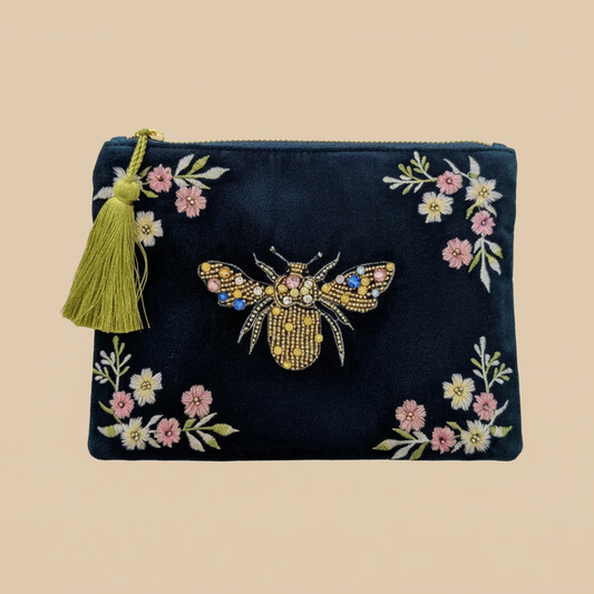 Meadow Bee embroidered velvet clutch bag on a shadow-free beige background