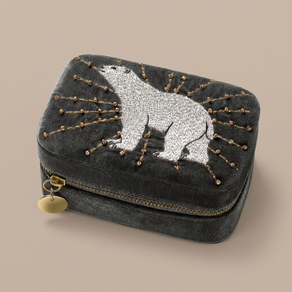 Arctic Glow charcoal-grey jewellery box with white polar bear embroidery and gold-tone bead details on a taupe-beige background